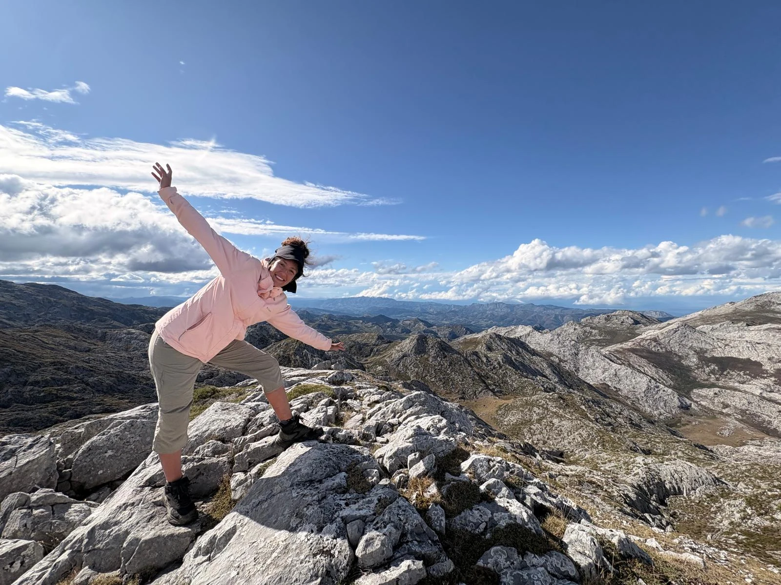 Helena enjoying a rocky mountain summit beneath a blue sky